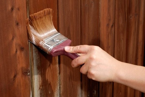 Painting the fence with a brush