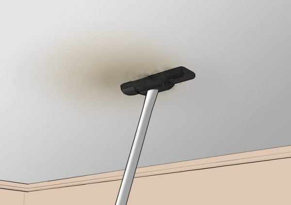 Fjernelse af grå plak fra loftet med en støvsuger