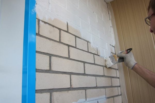 Pintando uma parede de tijolos com tinta de silicato