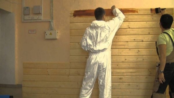 Painting a wooden wall inside a house with paint