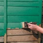 De muren van een houten huis schilderen