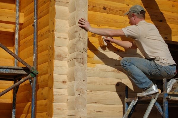 Il processo di verniciatura delle pareti di una casa di legno