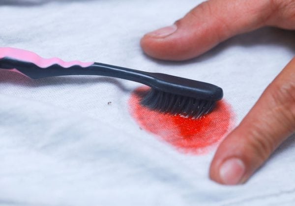 Ta bort färg från kläder med en tandborste och fläckborttagare