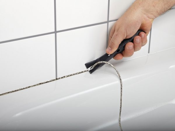 Removing the fungus-affected grout in the bathroom