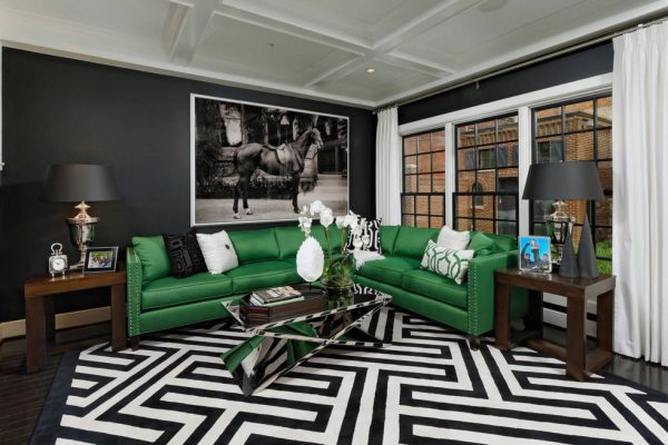 Green sofa against the background of black walls