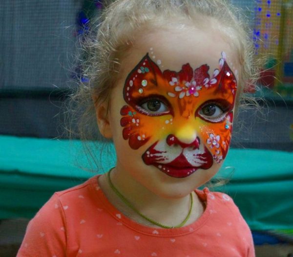 Face painting in the form of an animal face on the face of a child