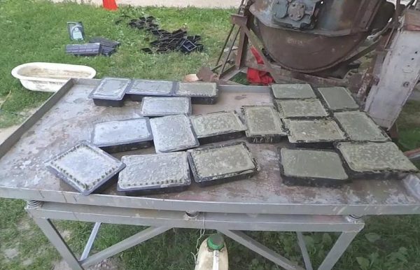 Production of concrete tiles on a vibrating table