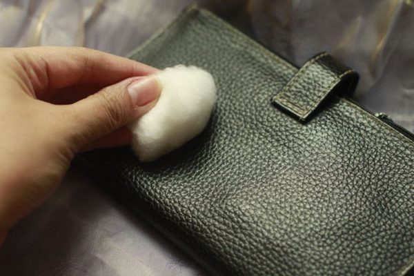 A foltok eltávolítása a pénztárcájából egy pamut tamponnal