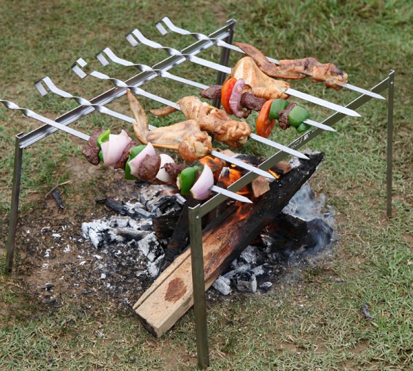 Una serie di ripiani pieghevoli e spiedini per cucinare il barbecue