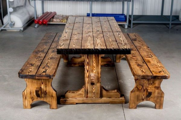 Spalony drewniany stół i ławki