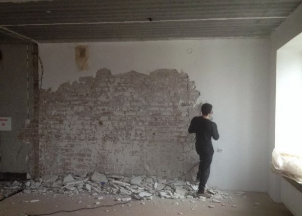 Desmontaje de yeso de una pared de ladrillos