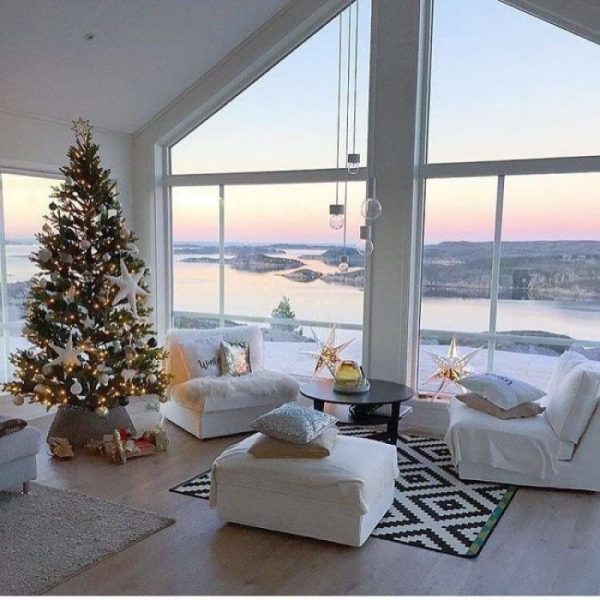 Interior con árbol de Navidad junto a la ventana en invierno